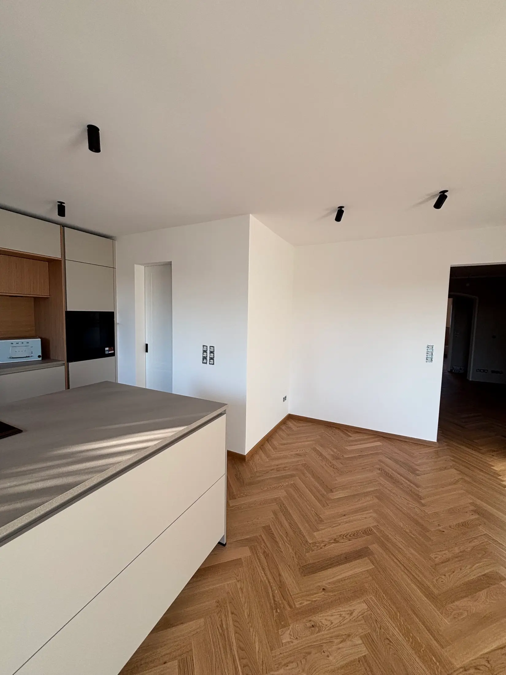 Offene Küche mit frisch gestrichenen Wänden und Fischgrätparkett in renovierter Wohnung