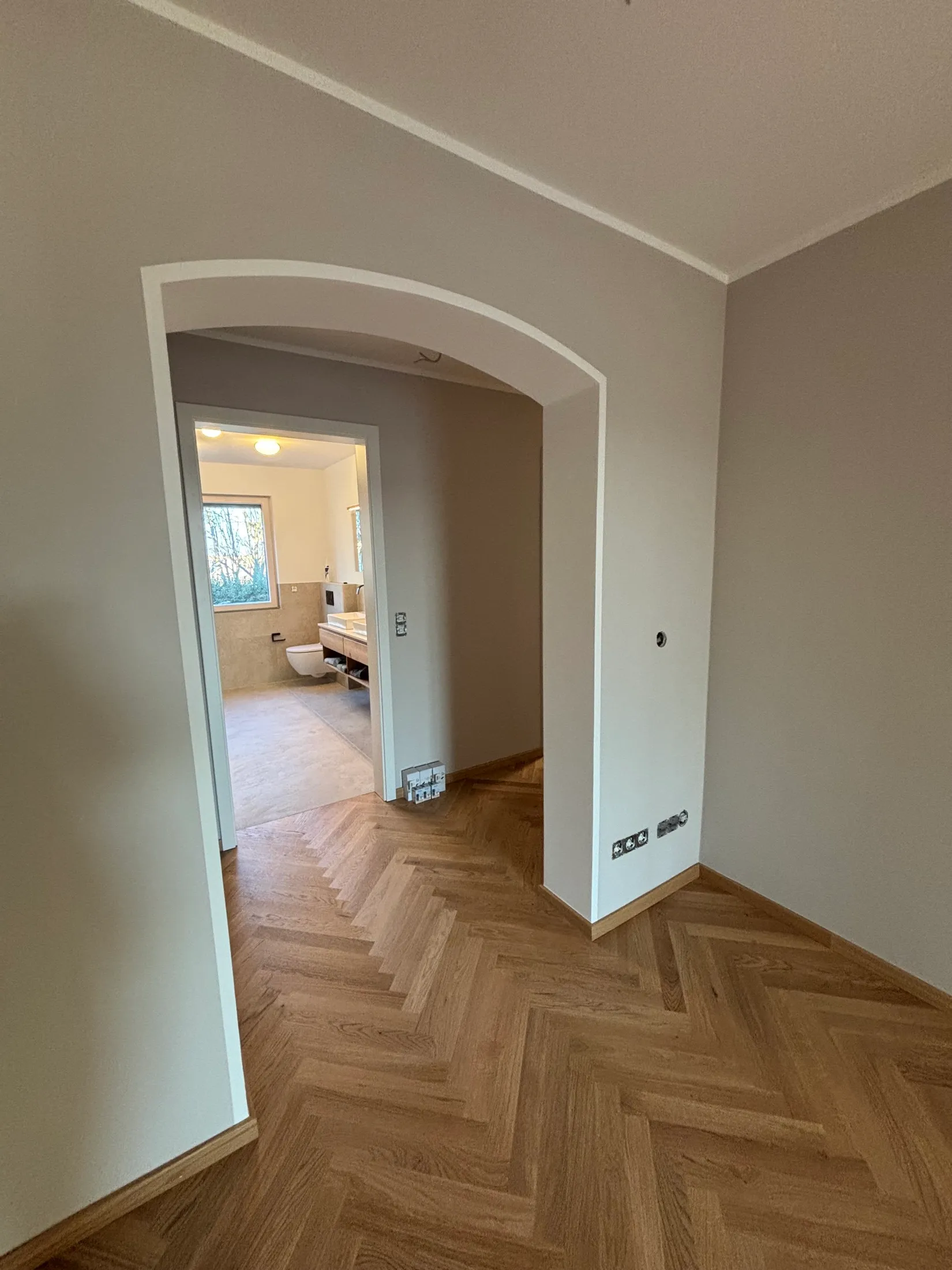 Renovierter Flur mit greige Wänden und weiß abgesetztem Rundbogen