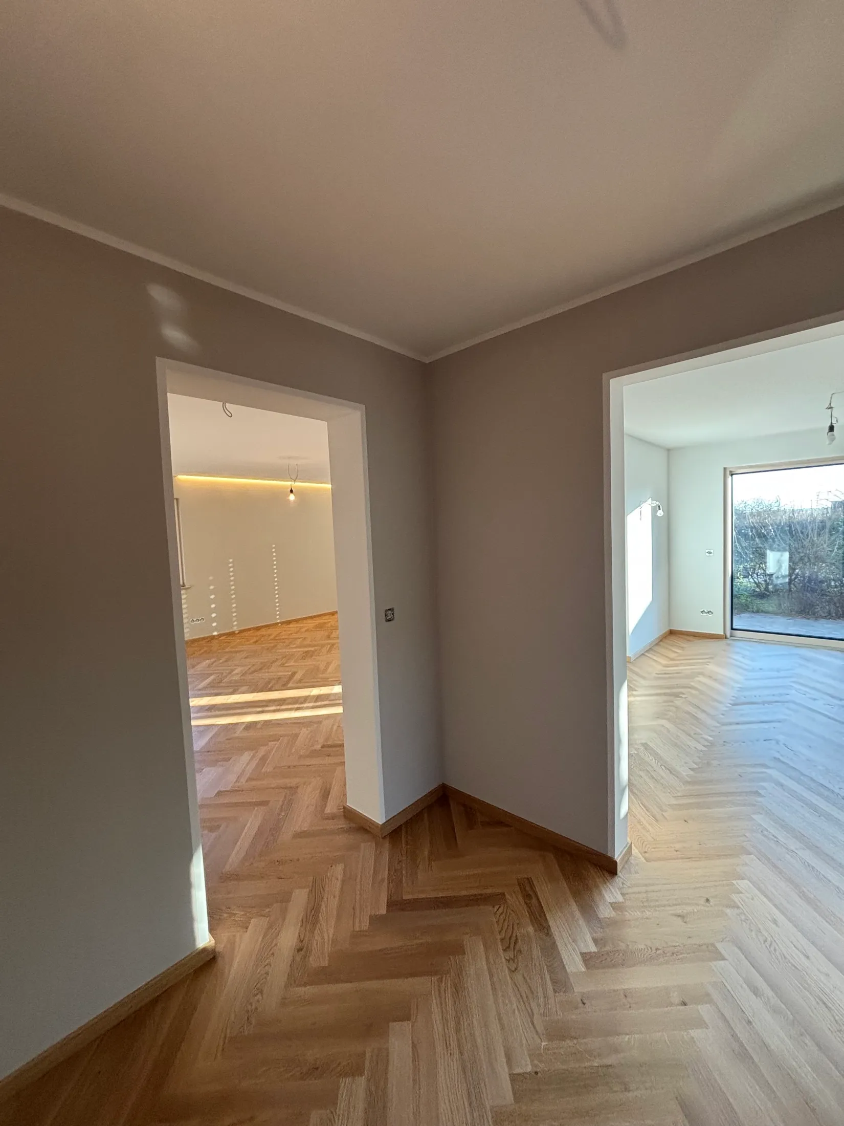 Blick durch renovierte Zimmer mit greige und weiß gestrichenen Wänden