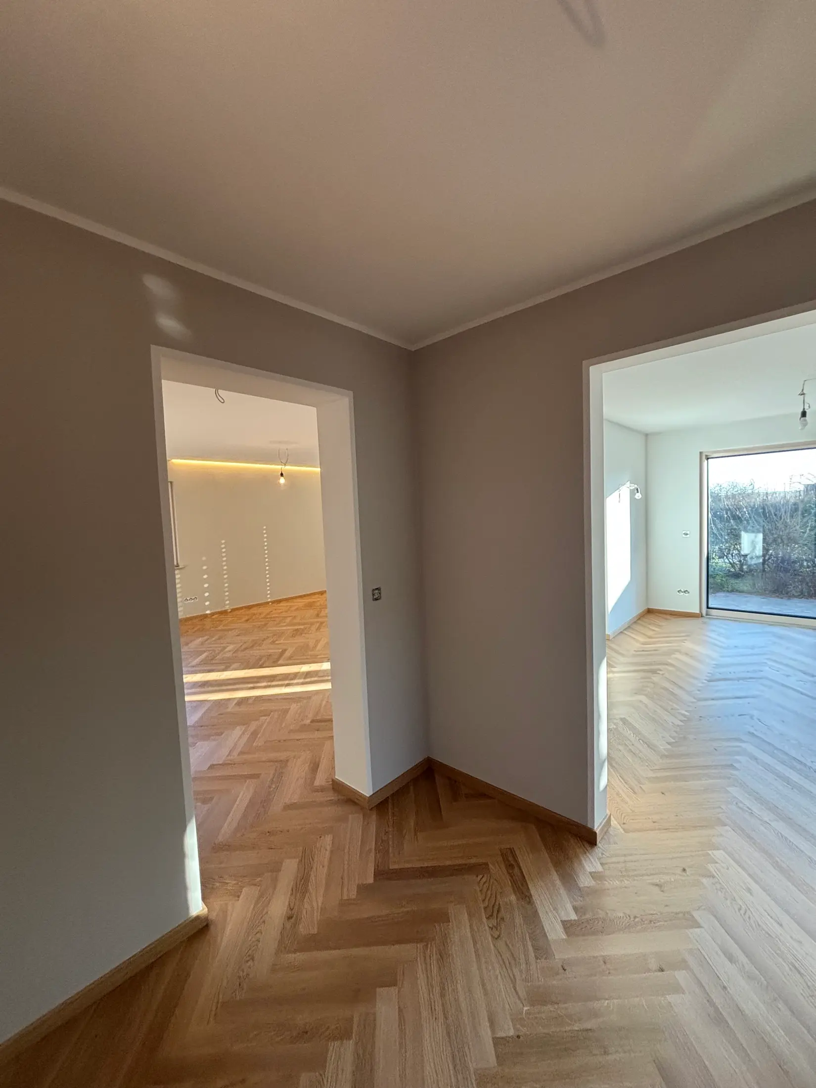 Raumfolge mit frisch gestrichenen Wänden und Eichenparkett in einer renovierten Wohnung