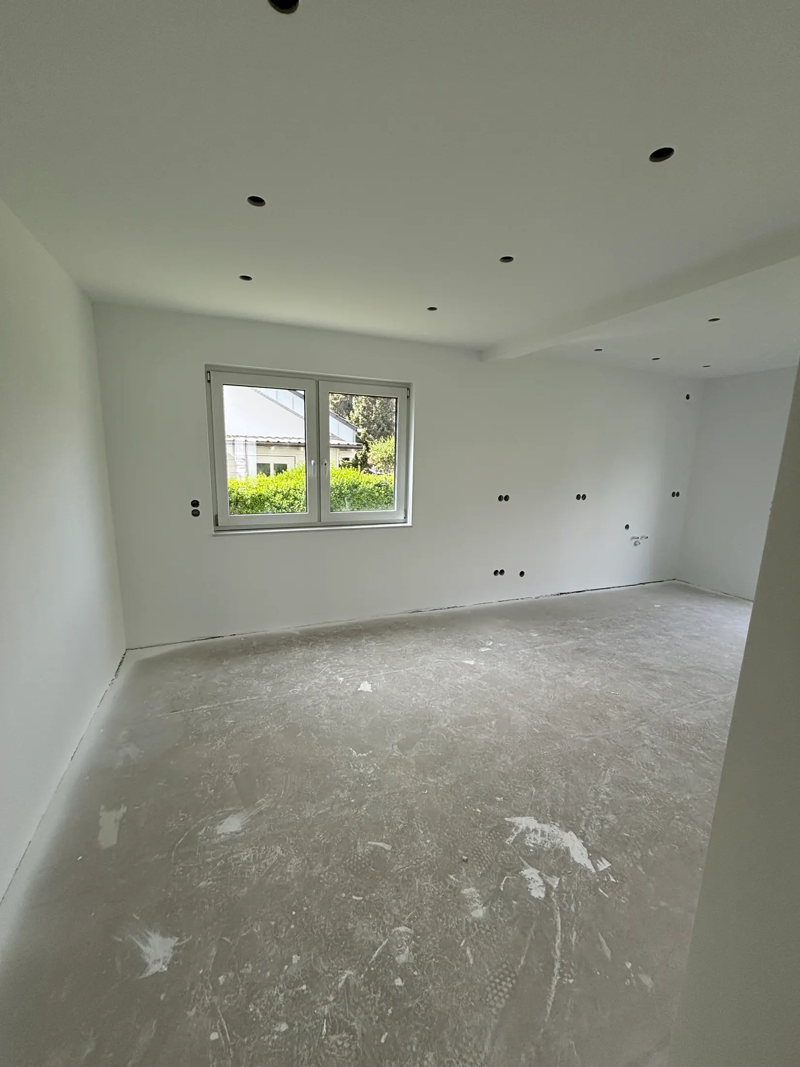 Weiß gestrichener Wohnraum mit neuer LED-Spotdecke nach der Kernsanierung
