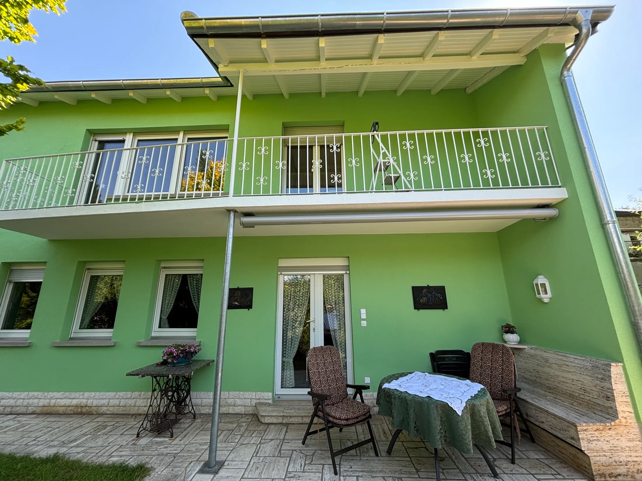 Fertig grün gestrichene Gartenfassade mit Balkon