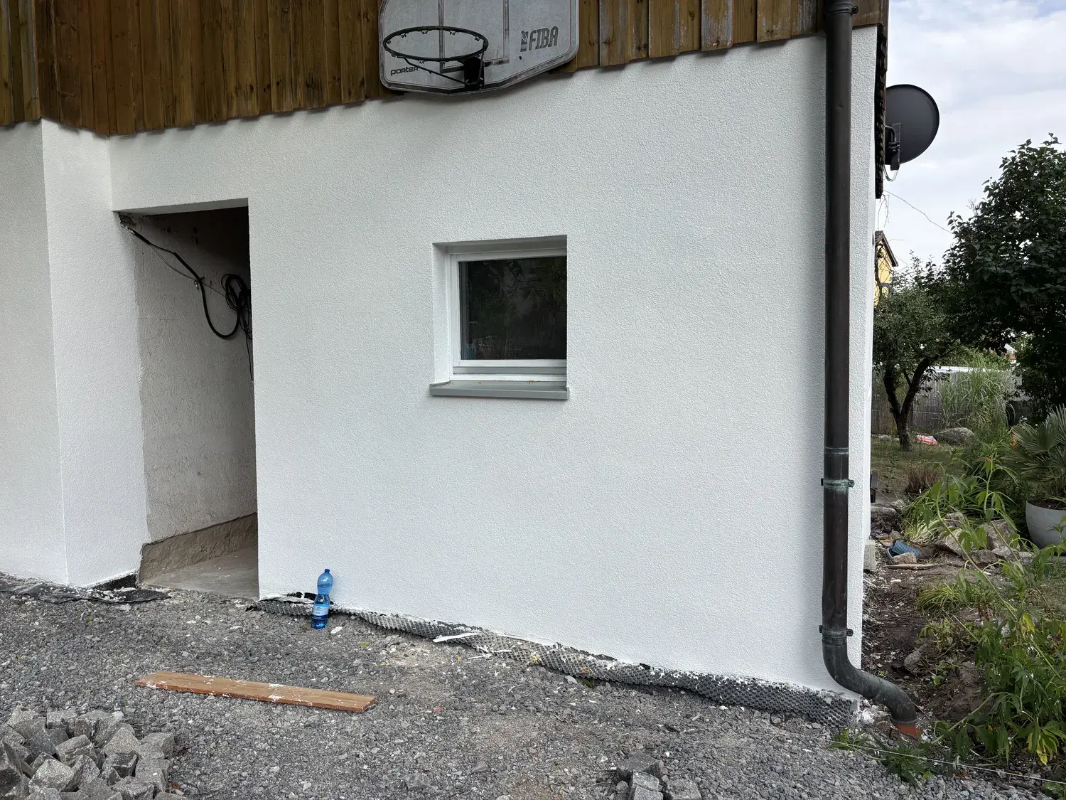 Dieselbe Hinterhofwand nach der Sanierung, frisch weiß gestrichen