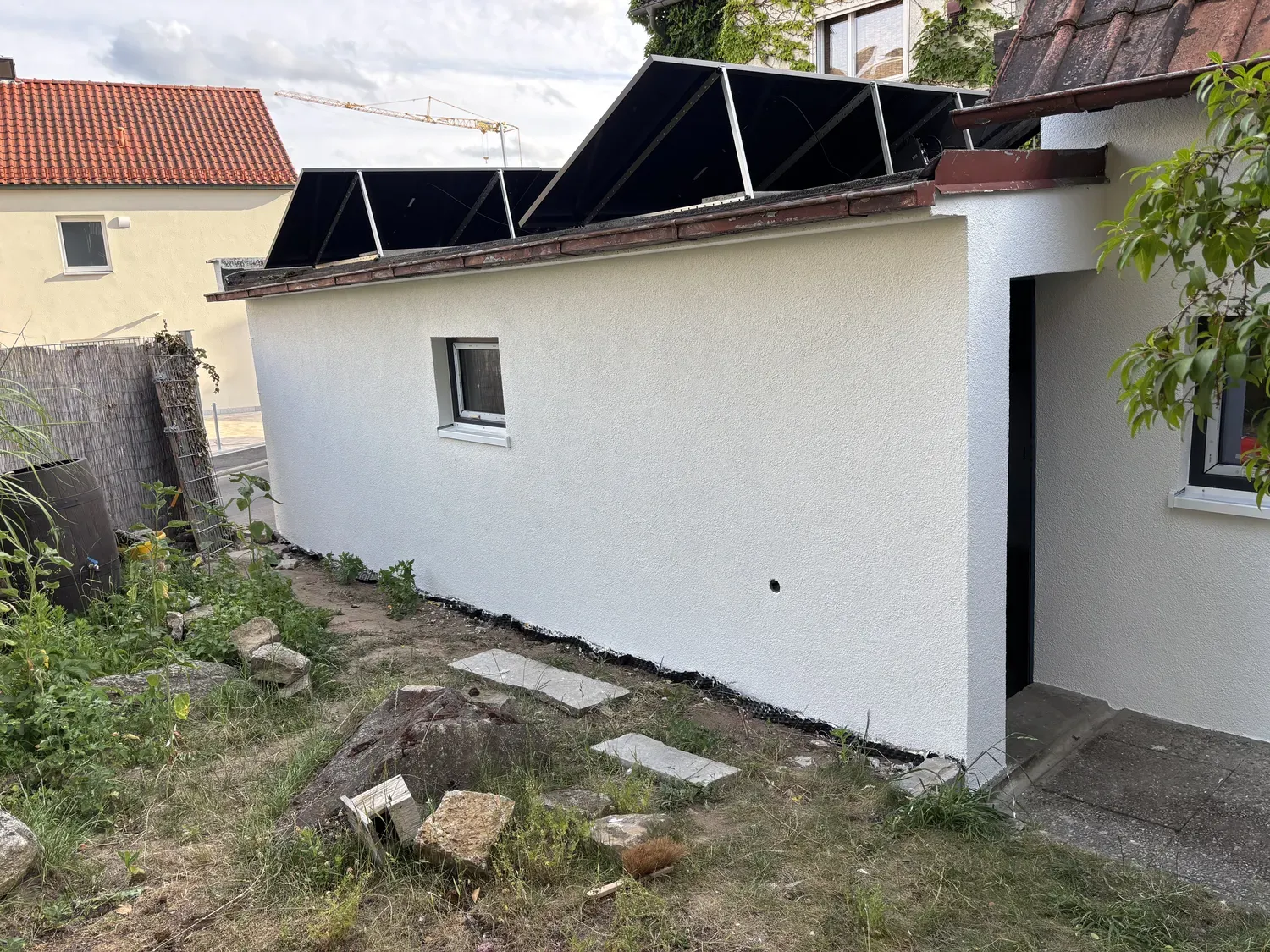 Frisch weiß verputzter Anbau mit Solarpaneelen auf dem Dach